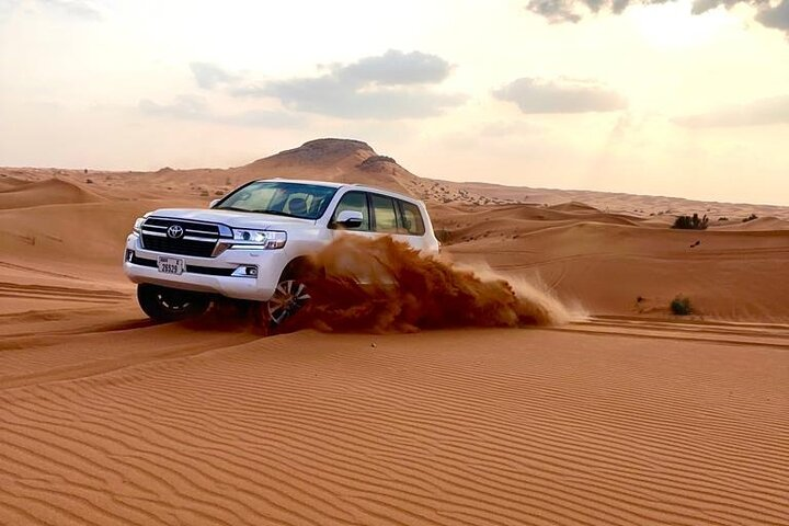 Experience the stunning red dunes of Dubai as you ride through the tranquil desert landscape capturing unforgettable moments and excitement in every twist and turn of your adventure.